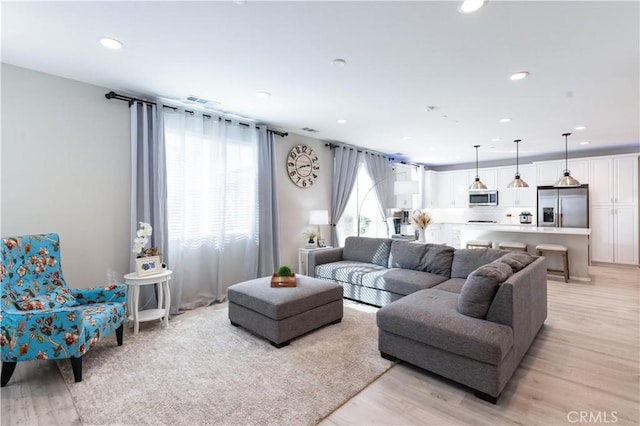 living area featuring light wood-type flooring and recessed lighting