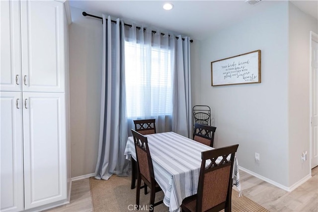 dining area featuring light wood-type flooring and baseboards