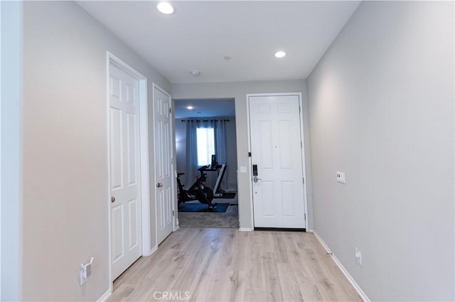 corridor with recessed lighting, light wood-type flooring, and baseboards