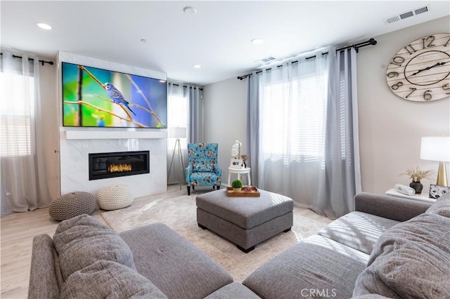 living area with a fireplace, visible vents, and recessed lighting