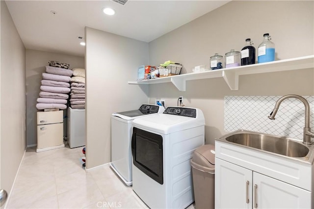 washroom with recessed lighting, cabinet space, light tile patterned flooring, a sink, and independent washer and dryer