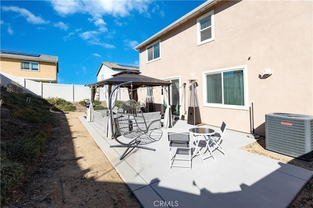 view of patio featuring fence, central AC unit, and a gazebo