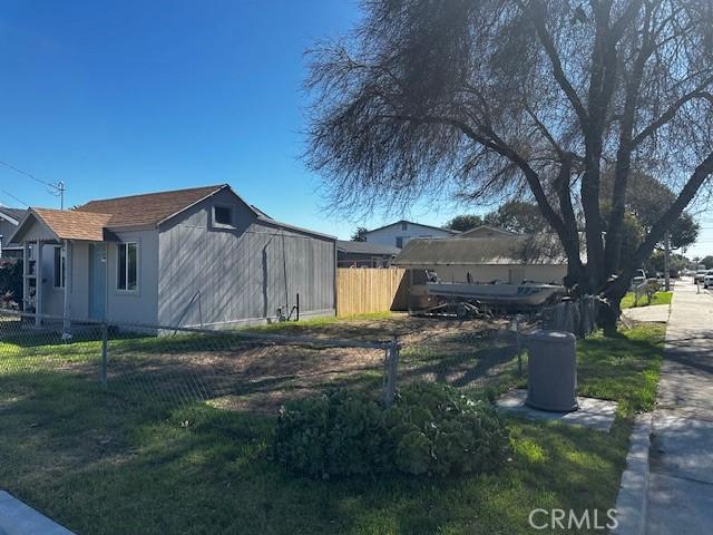 view of property exterior with fence and a lawn