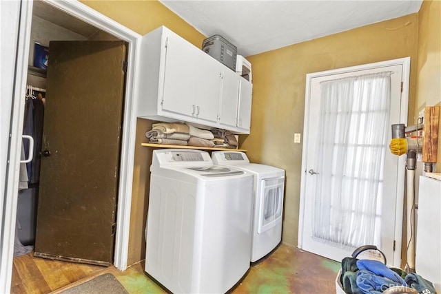 clothes washing area with cabinet space and separate washer and dryer