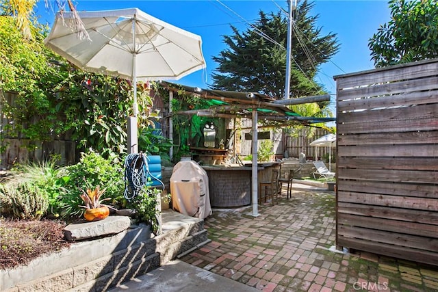 view of patio with outdoor dry bar and a fenced backyard