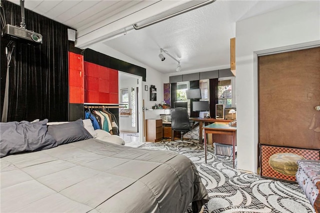 bedroom featuring lofted ceiling with beams and rail lighting