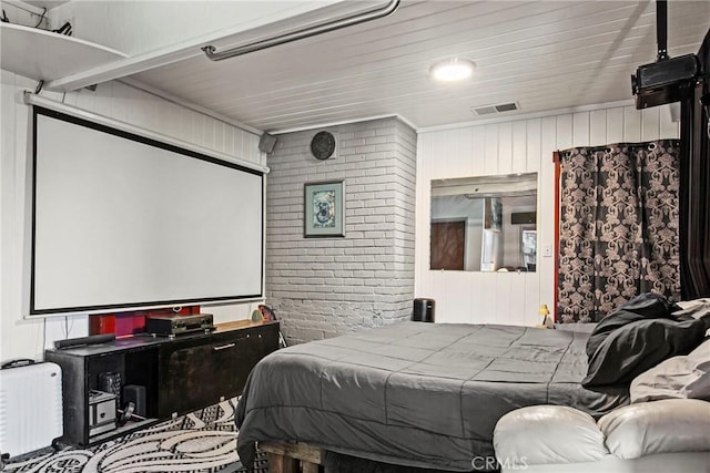 bedroom featuring brick wall and visible vents