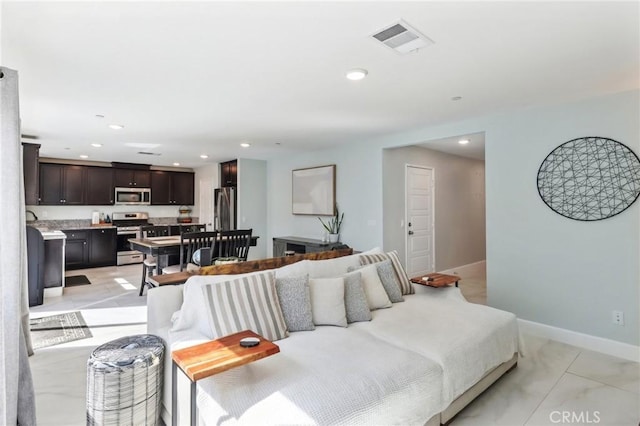 living area featuring baseboards, visible vents, and recessed lighting