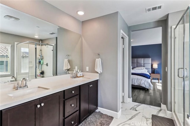 full bath featuring marble finish floor, a shower stall, visible vents, and a sink