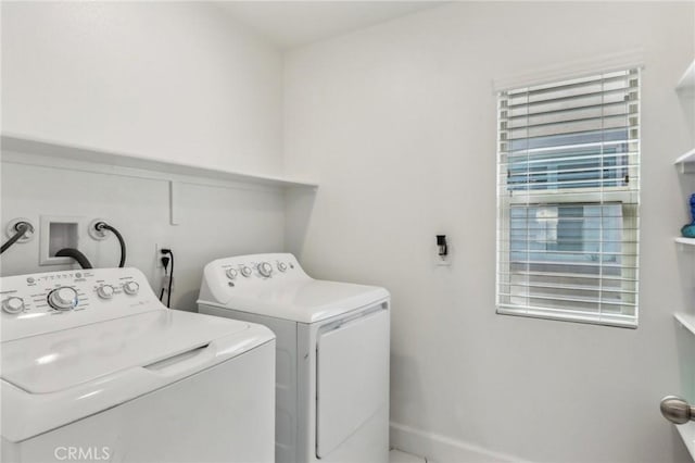 clothes washing area with laundry area, washing machine and clothes dryer, and baseboards