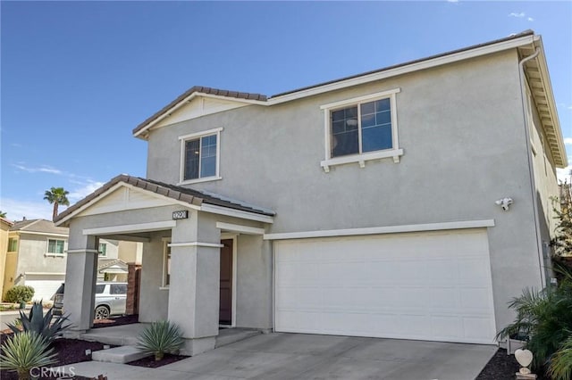 traditional-style house featuring driveway, a tiled roof, an attached garage, and stucco siding