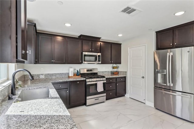 kitchen featuring marble finish floor, visible vents, appliances with stainless steel finishes, a sink, and dark brown cabinets