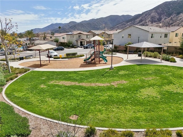 view of property's community featuring a lawn, a residential view, a mountain view, and playground community