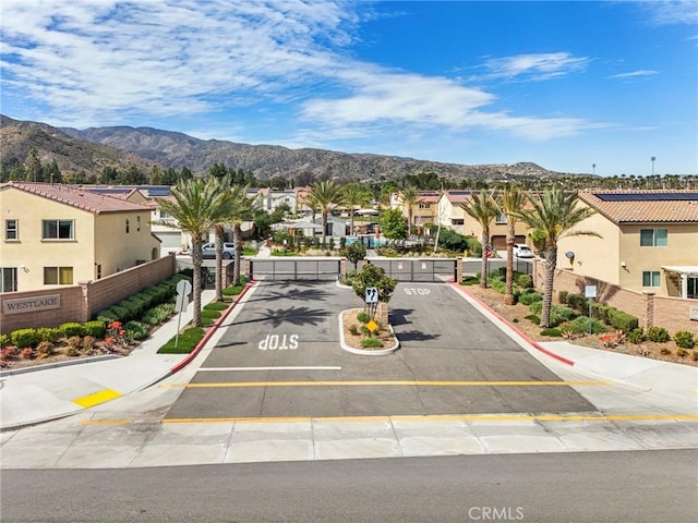 exterior space with a mountain view, uncovered parking, fence, and a residential view