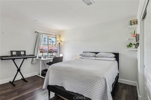 bedroom featuring baseboards, visible vents, and wood finished floors