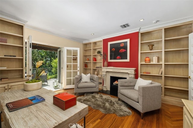 sitting room with built in features, recessed lighting, visible vents, ornamental molding, and a lit fireplace