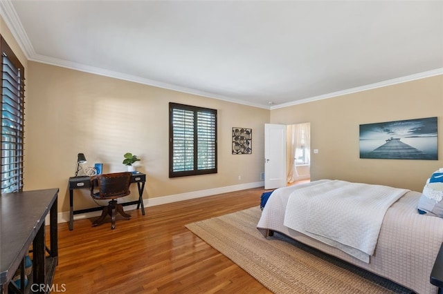 bedroom with crown molding, baseboards, and wood finished floors