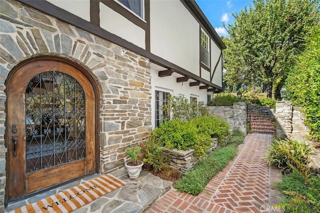 view of exterior entry with stone siding and stucco siding