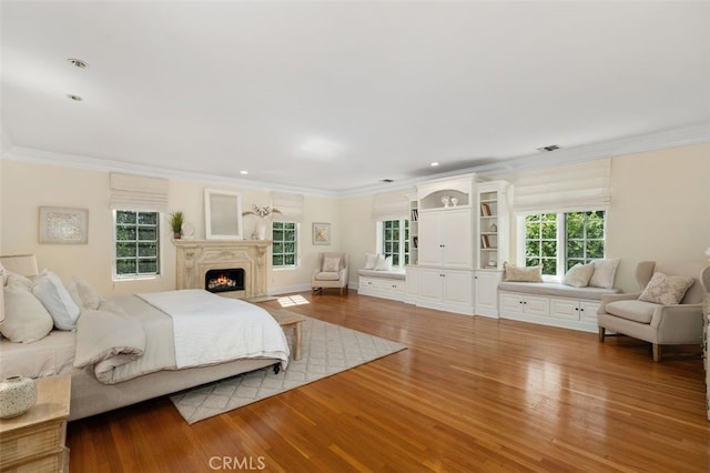 bedroom featuring visible vents, ornamental molding, and wood finished floors