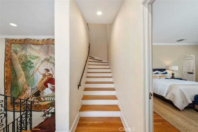 stairway featuring baseboards, visible vents, ornamental molding, wood finished floors, and recessed lighting