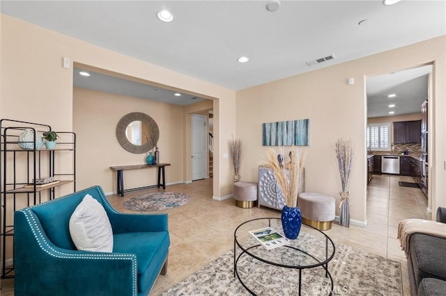 living room featuring baseboards, light tile patterned flooring, visible vents, and recessed lighting