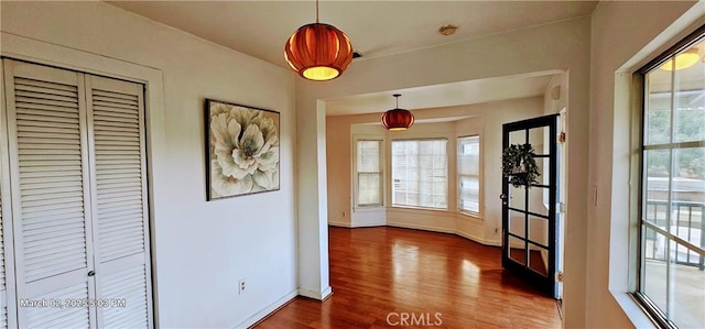 doorway featuring baseboards and wood finished floors