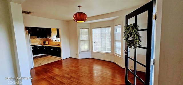 interior space with baseboards, visible vents, dark wood-type flooring, and a sink