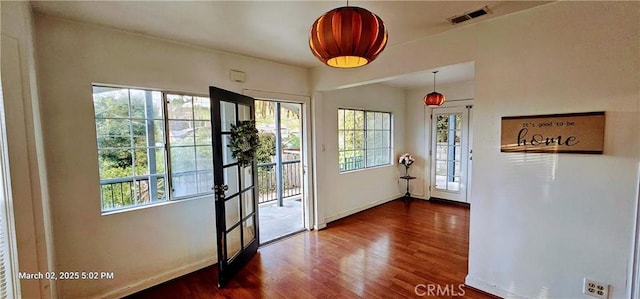 doorway with dark wood-style floors, visible vents, and plenty of natural light