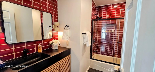 bathroom with enclosed tub / shower combo, vanity, and decorative backsplash