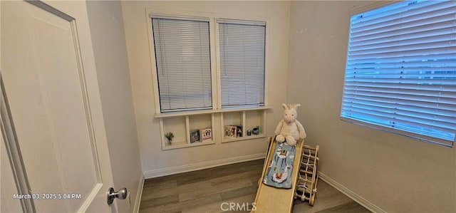 recreation room with baseboards and wood finished floors