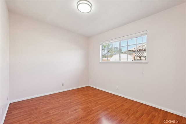 spare room with wood finished floors and baseboards