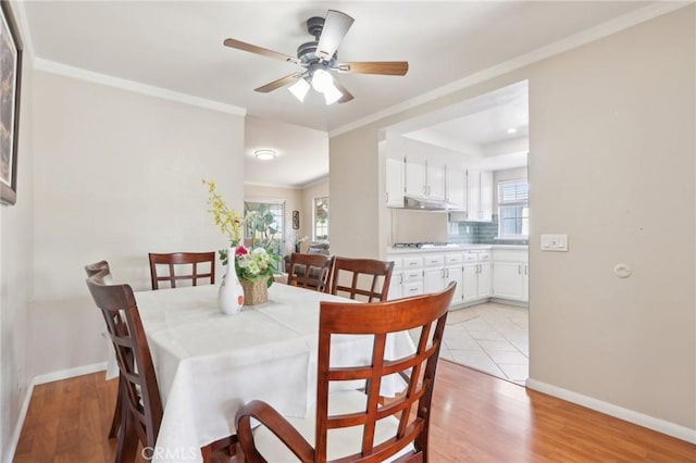 dining room with light wood-style flooring, a ceiling fan, crown molding, and baseboards