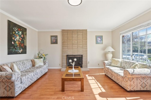 living room with a fireplace, wood finished floors, baseboards, and ornamental molding