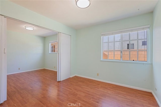 unfurnished room featuring baseboards and wood finished floors
