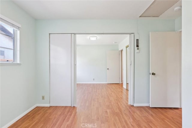 hallway with baseboards and light wood finished floors