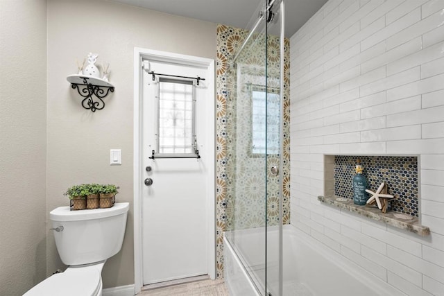 bathroom with toilet and enclosed tub / shower combo