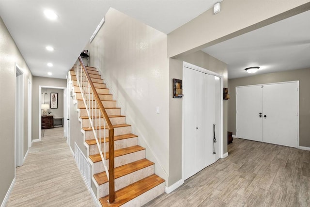 staircase featuring recessed lighting, baseboards, and wood finished floors