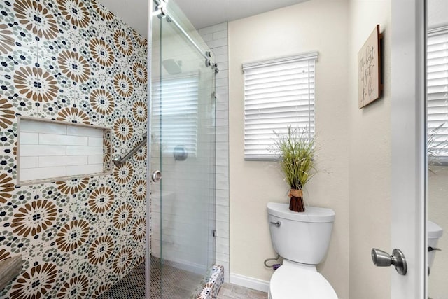 bathroom featuring toilet and a stall shower