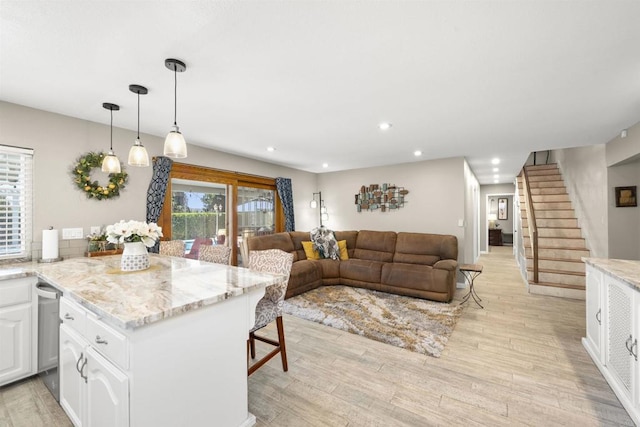 kitchen featuring white cabinets, recessed lighting, open floor plan, and light wood finished floors