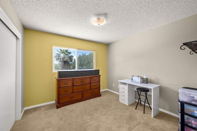 home office with light colored carpet, a textured ceiling, and baseboards