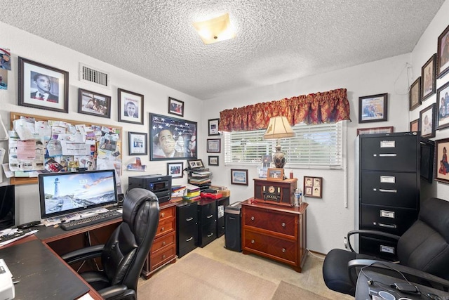 office area with a textured ceiling, visible vents, and light carpet