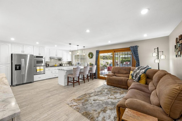 living area with recessed lighting and light wood-type flooring