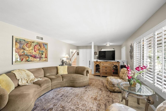 living room with stairway and visible vents