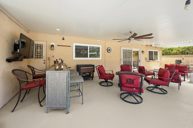 view of patio / terrace with outdoor dining space, an outdoor living space, a ceiling fan, and fence