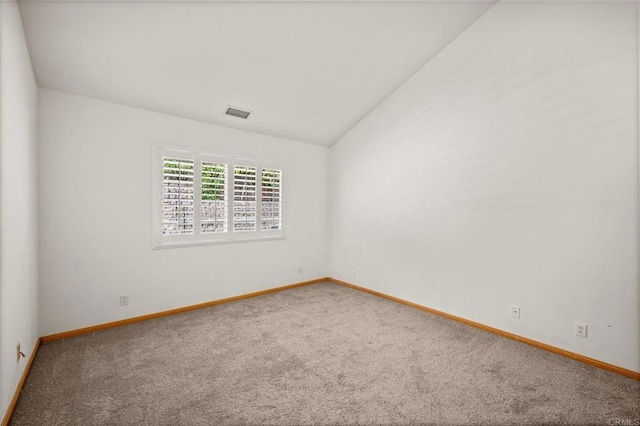 unfurnished room with lofted ceiling, carpet floors, visible vents, and baseboards