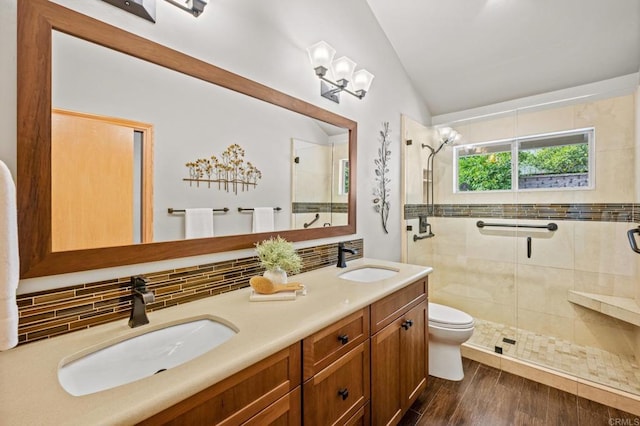 full bathroom with vaulted ceiling, a sink, backsplash, and a shower stall