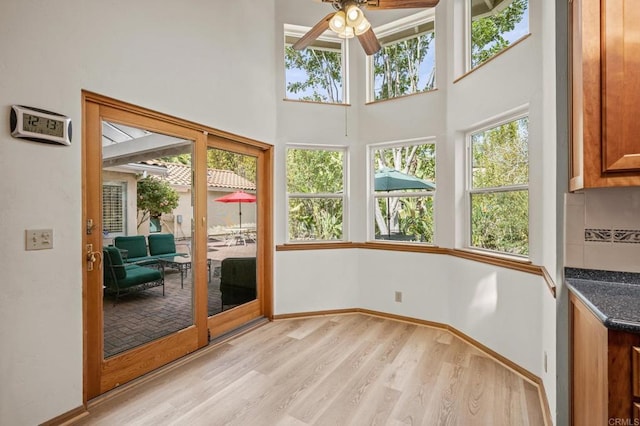 unfurnished sunroom with ceiling fan