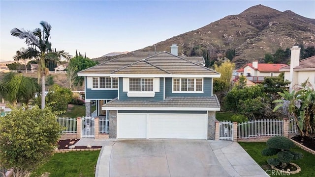 view of front of house with a garage, driveway, a gate, and a tiled roof