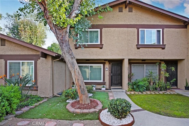 view of property with stucco siding and a front yard