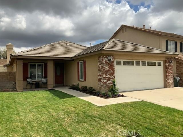 view of front of property featuring concrete driveway, brick siding, a front yard, and stucco siding